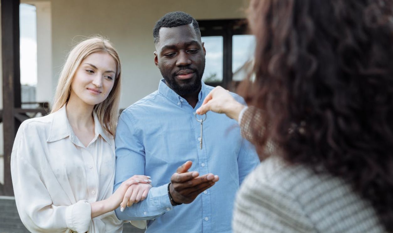 A Person with Curly Hair Handing the Key to the Owners
