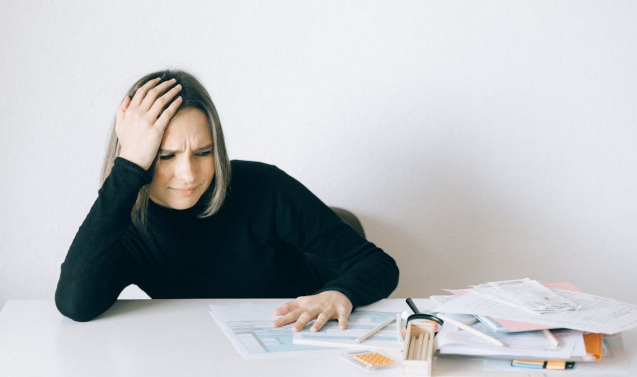 Woman in Black Long Sleeve Shirt Sitting with Hand on her Head