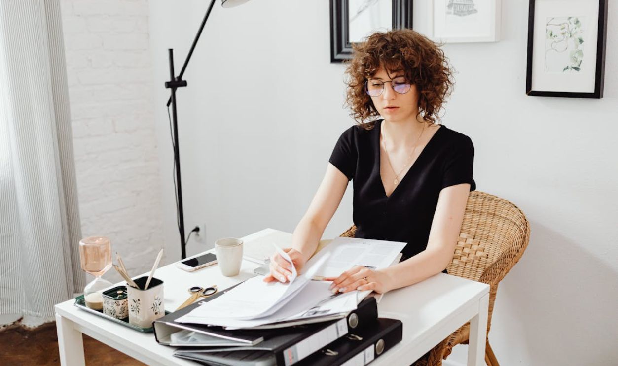 Woman Sitting by Table and Working