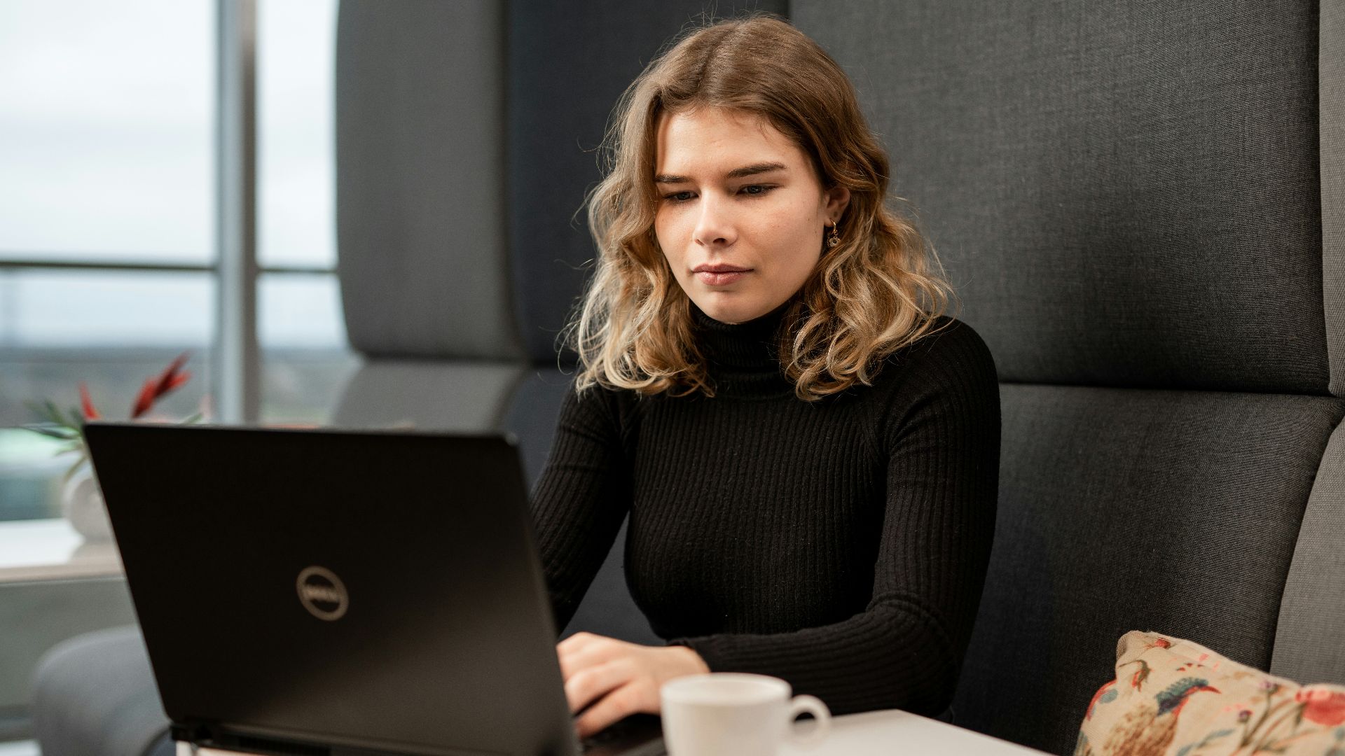 a woman sitting at a table with a laptop