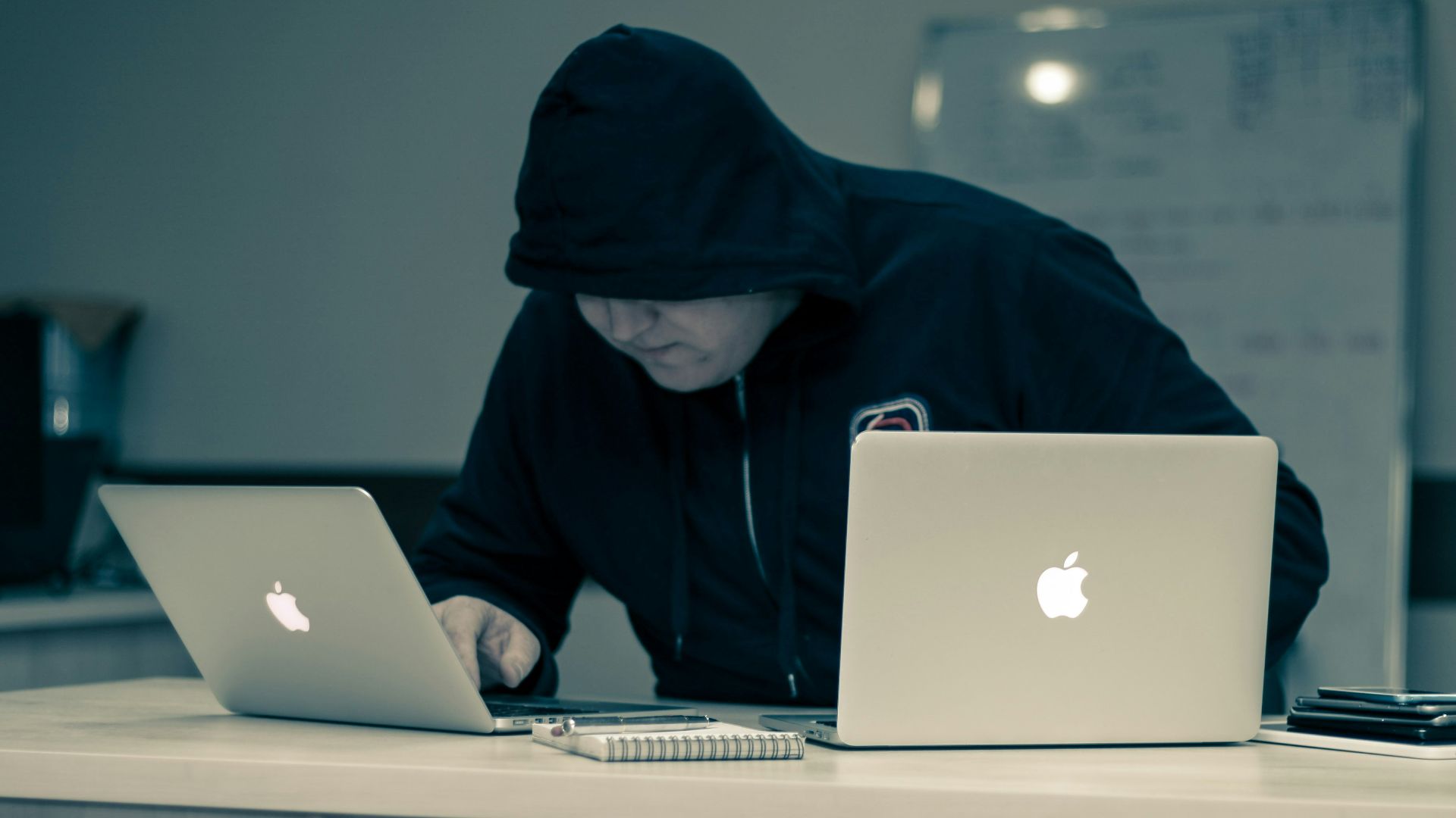 man in black hoodie using macbook