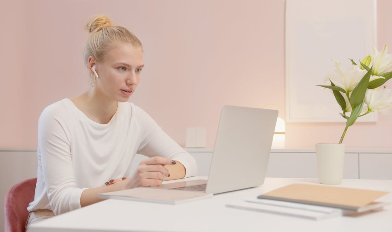 A Woman Sitting in Front of a Laptop with Airpods