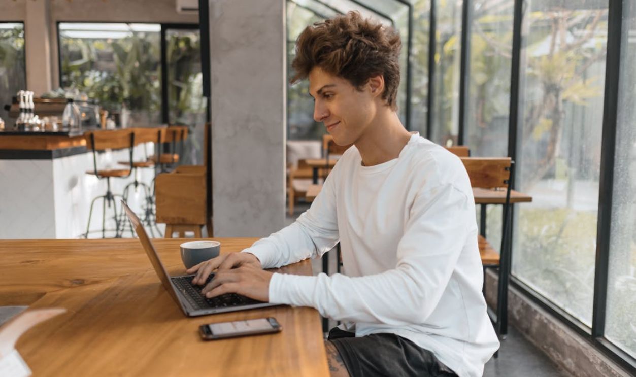 Young Man Working on a Laptop in a Cafe