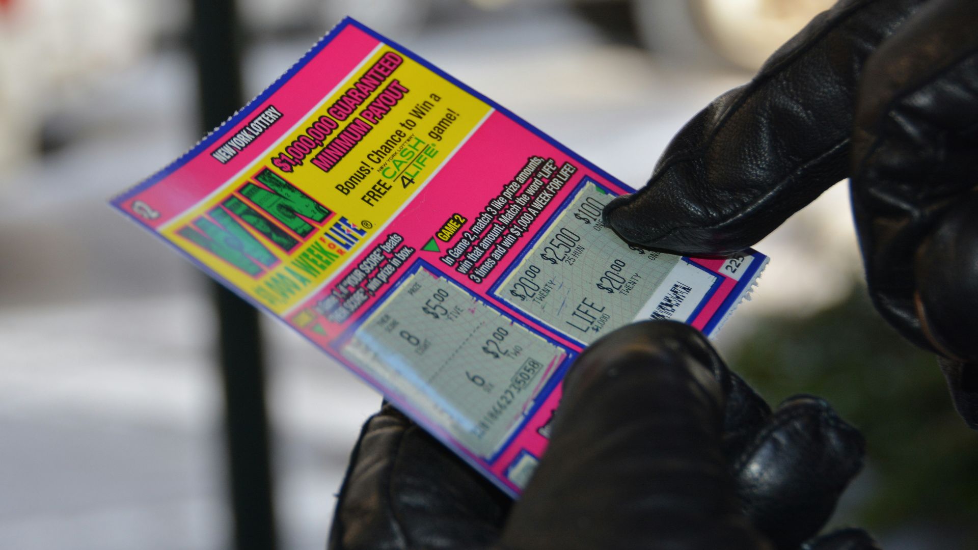 a person in black gloves holding a ticket