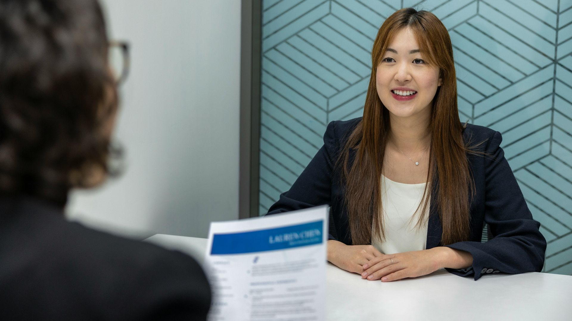 a woman sitting at a table with a piece of paper in front of her