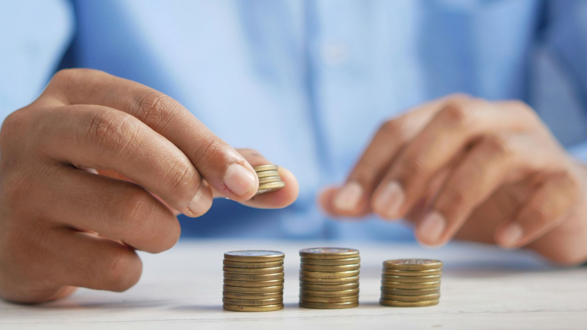 a person stacking coins on top of a table