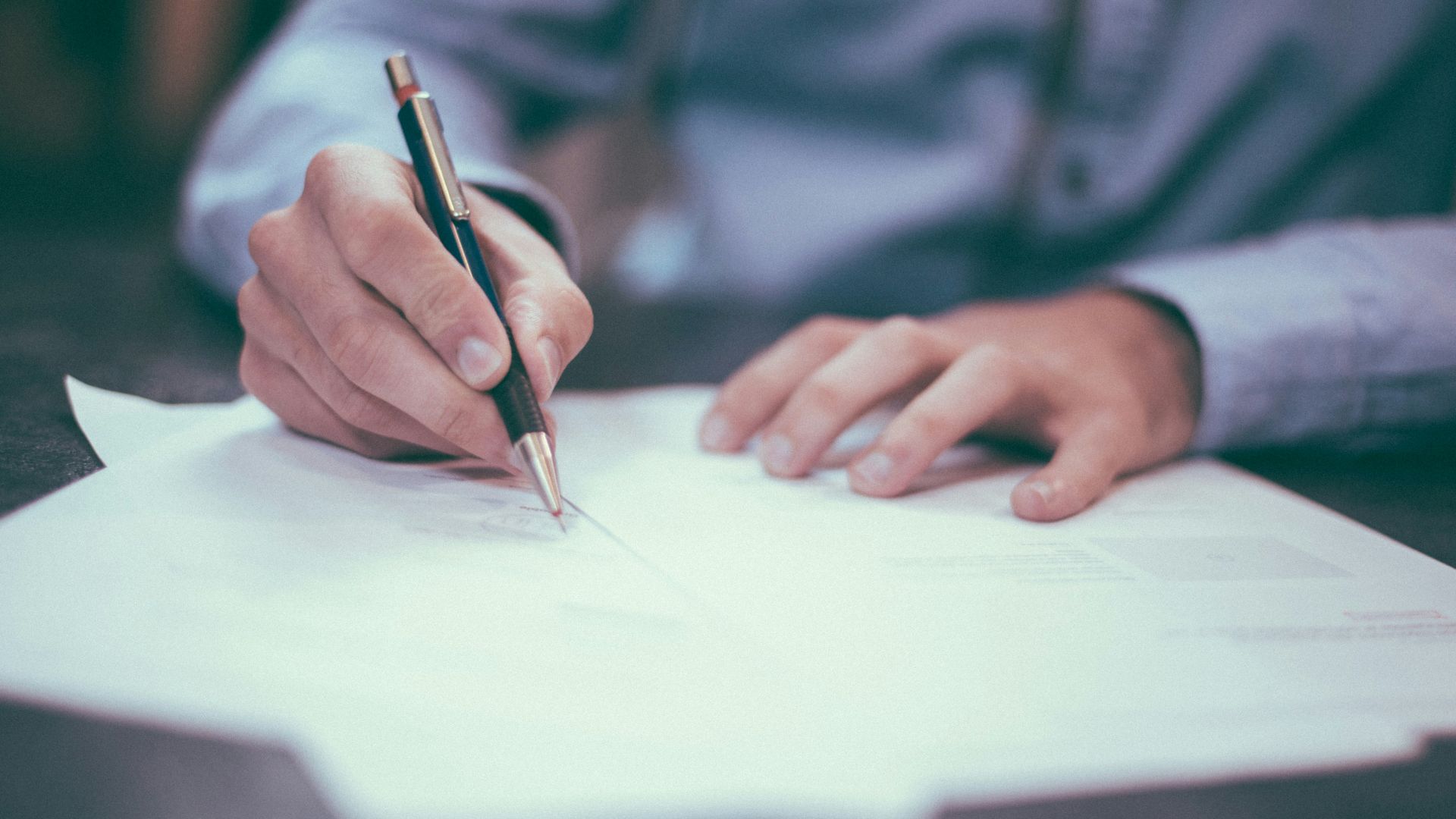 man writing on paper