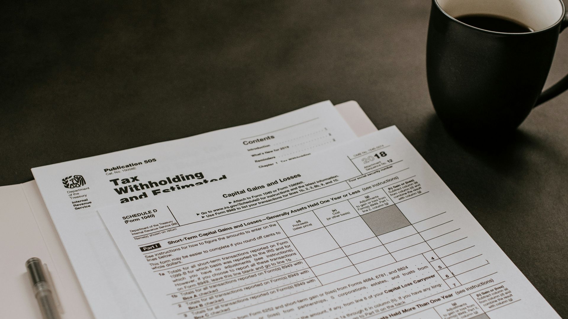 black ceramic mug beside white printer paper
