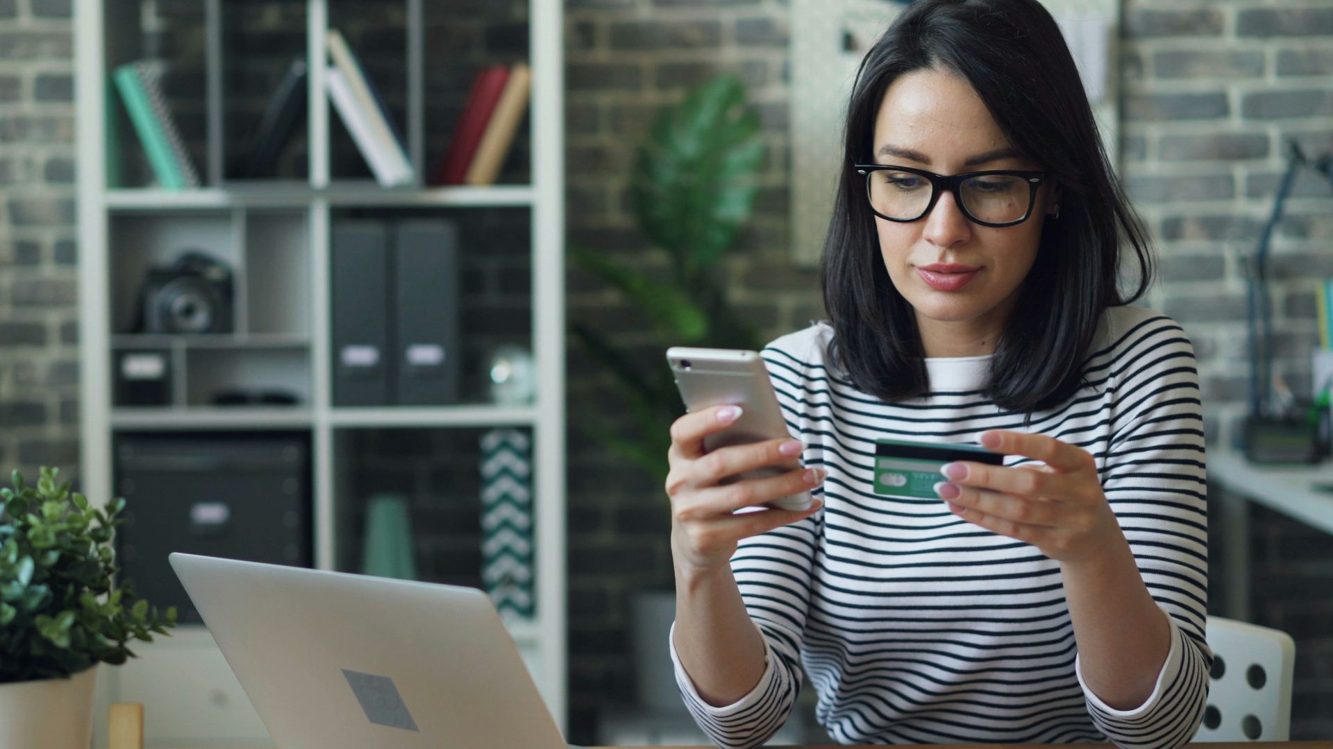 a woman sitting at a table looking at her cell phone