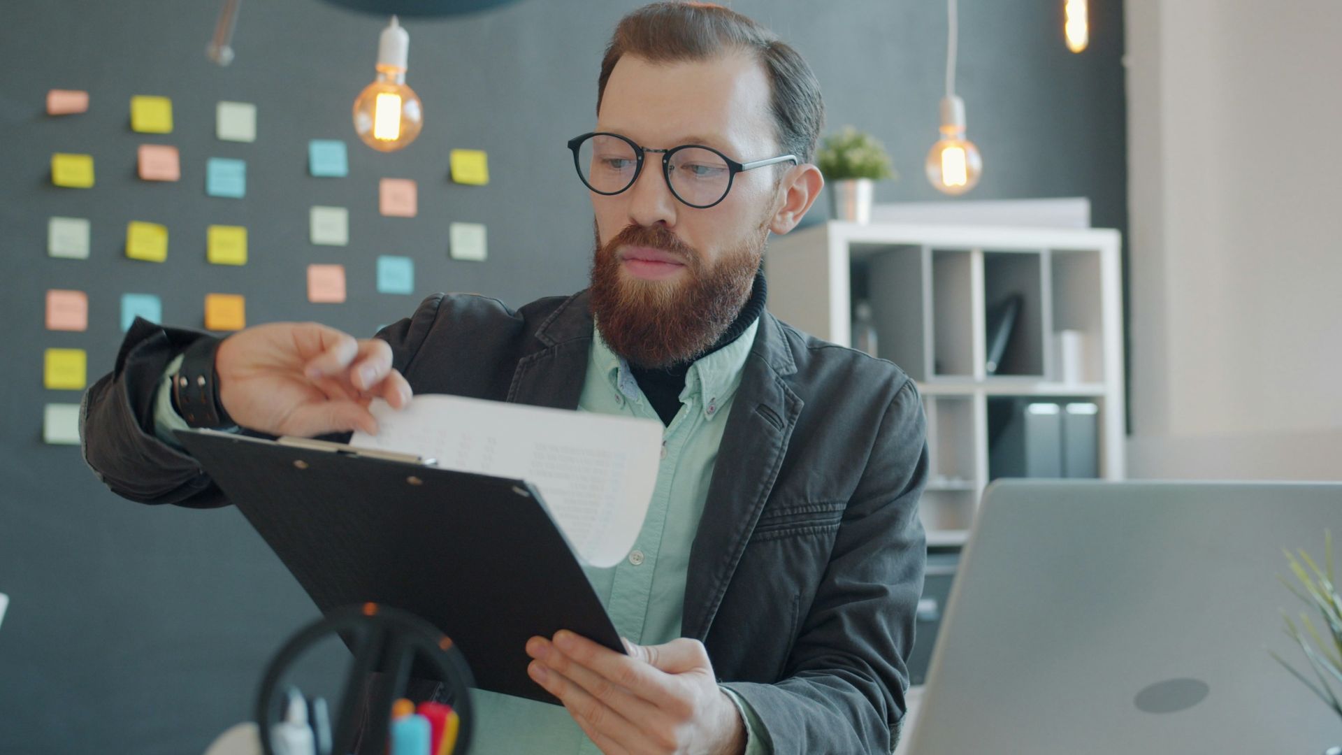 Man in glasses reviewing documents at desk