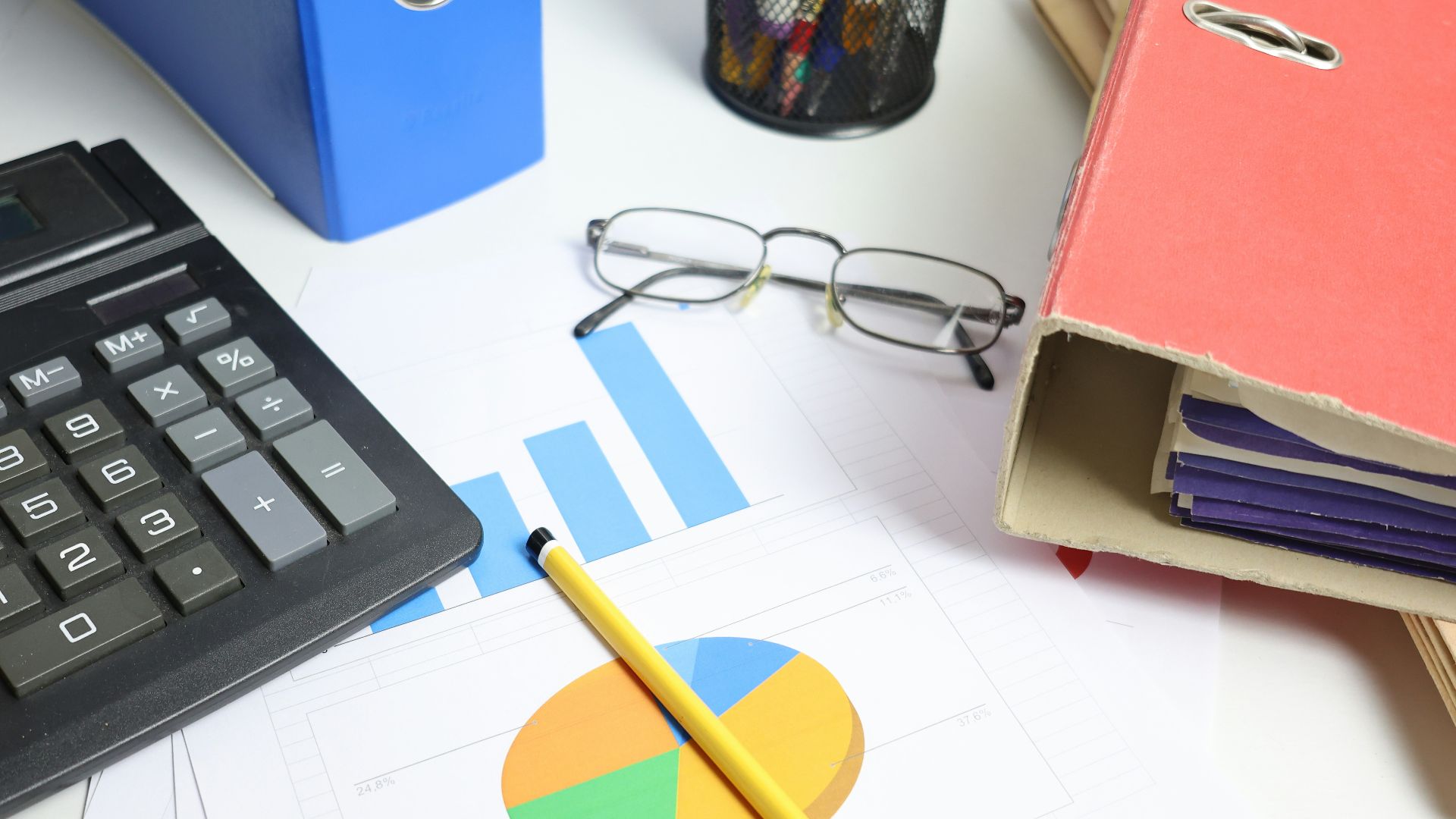 Desk with calculator, charts, and binders
