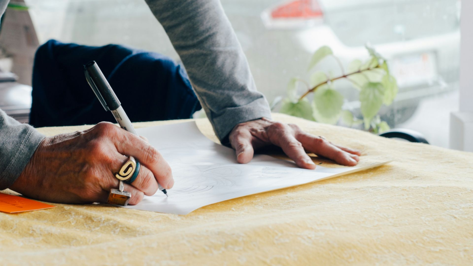person writing on white plain paper on the table photography