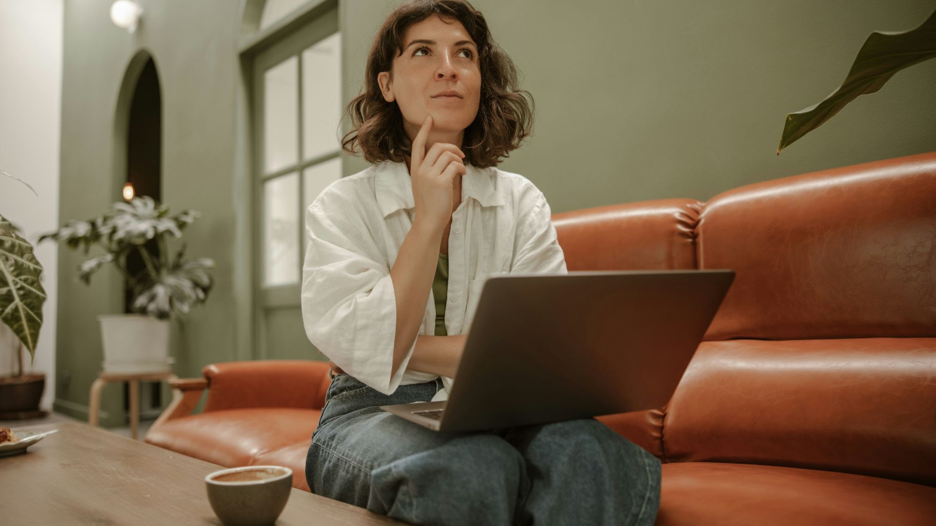 a woman sitting on a couch using a laptop computer
