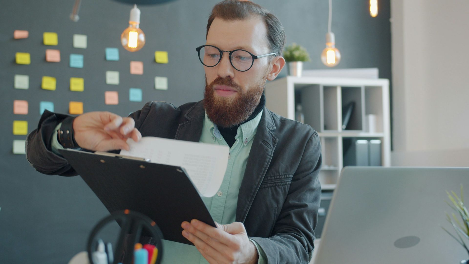 Man in glasses reviewing documents at desk
