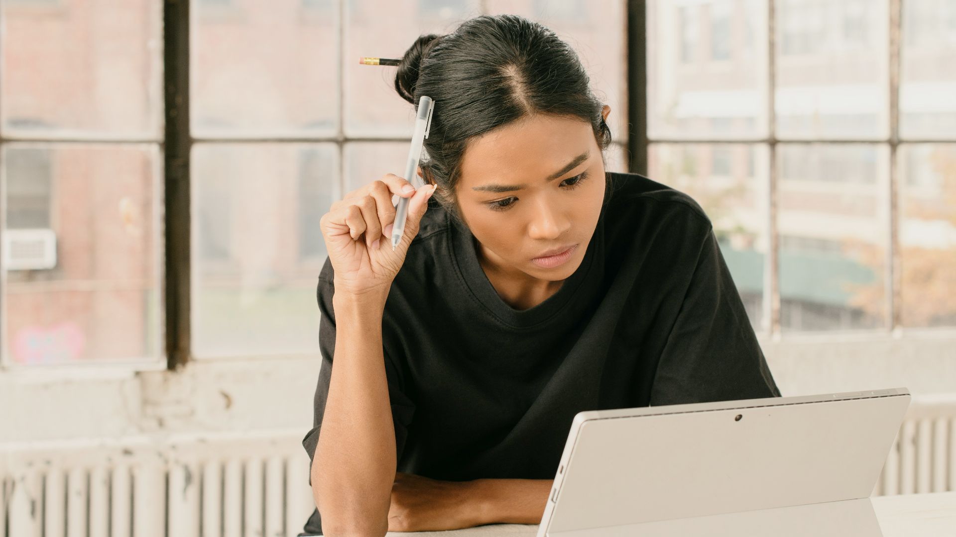 a woman sitting at a table using a laptop computer
