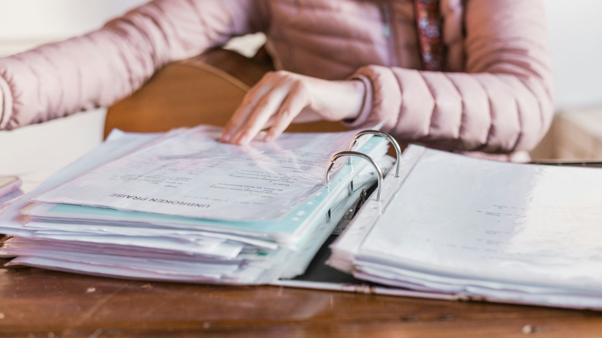 woman in white long sleeve shirt sitting beside brown wooden table