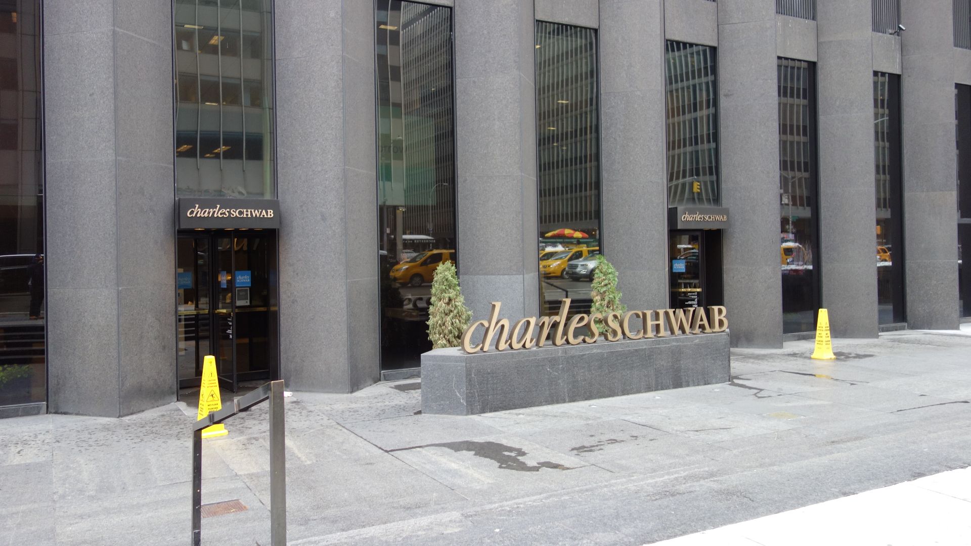 The CBS Building (51 West 52nd Street), on the east side of Sixth Avenue between 52nd and 53rd Streets in Midtown Manhattan. Pictured are signs for Charles Schwab.