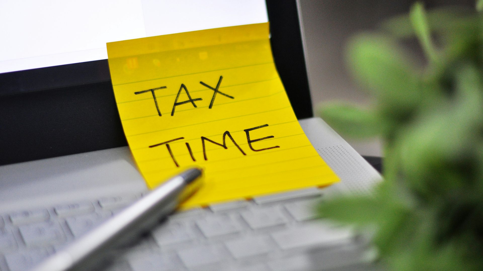 Yellow sticky note with tax time written on it.
