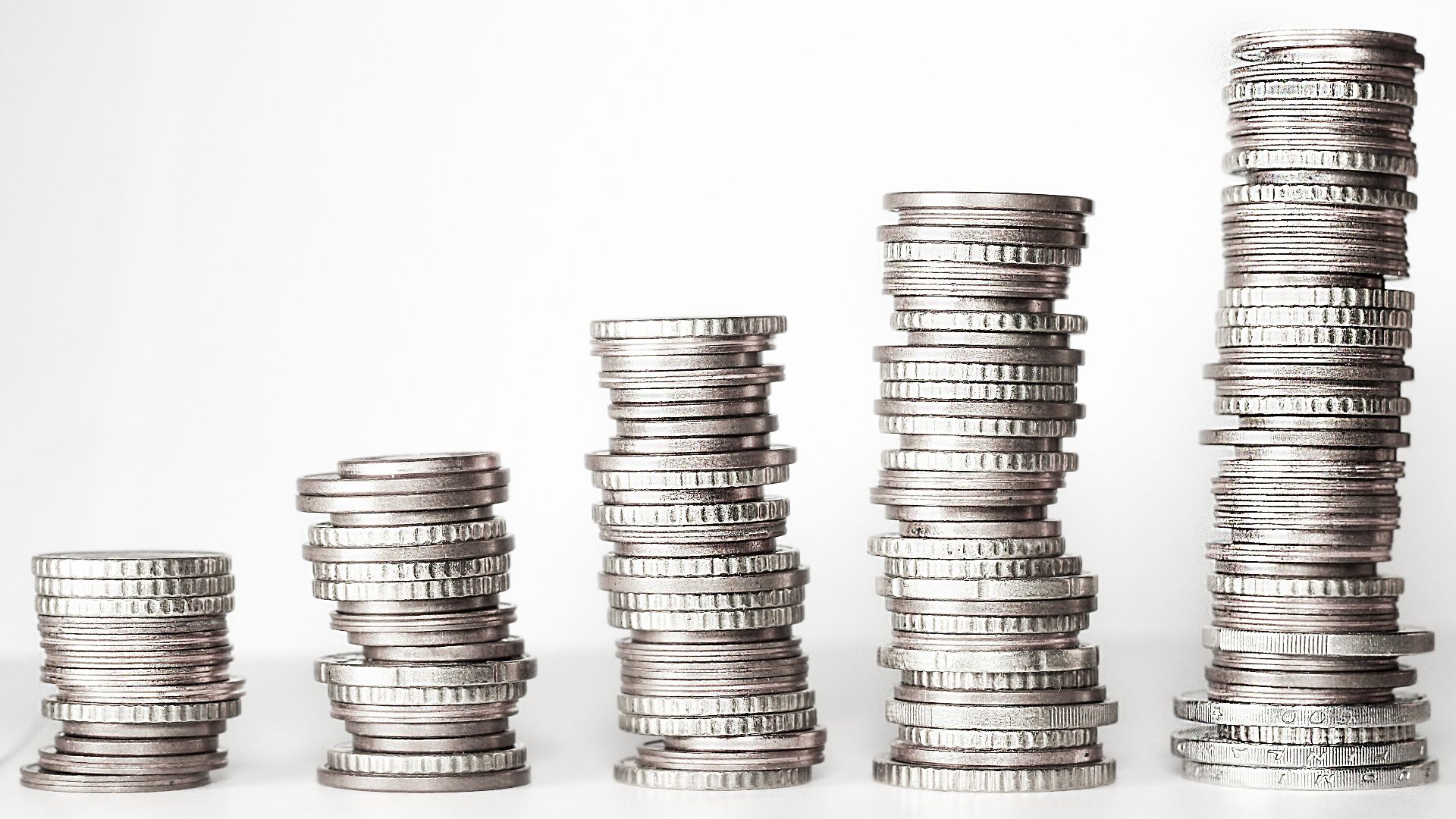 Shows 5 stacks of coins in the picture with a unknown currency