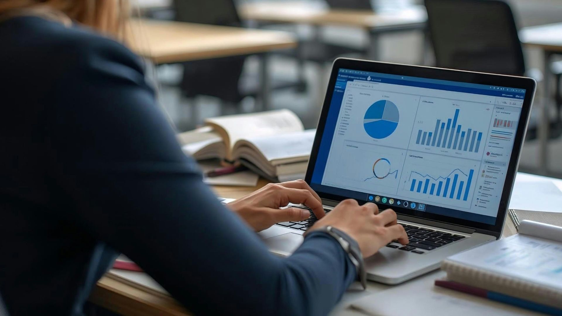Woman working on laptop with charts and graphs.