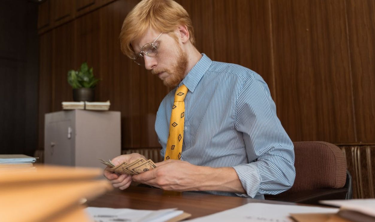 A Man Counting Money in the Office