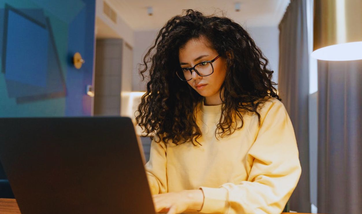 A Woman in Yellow Sweater Working on Her Laptop