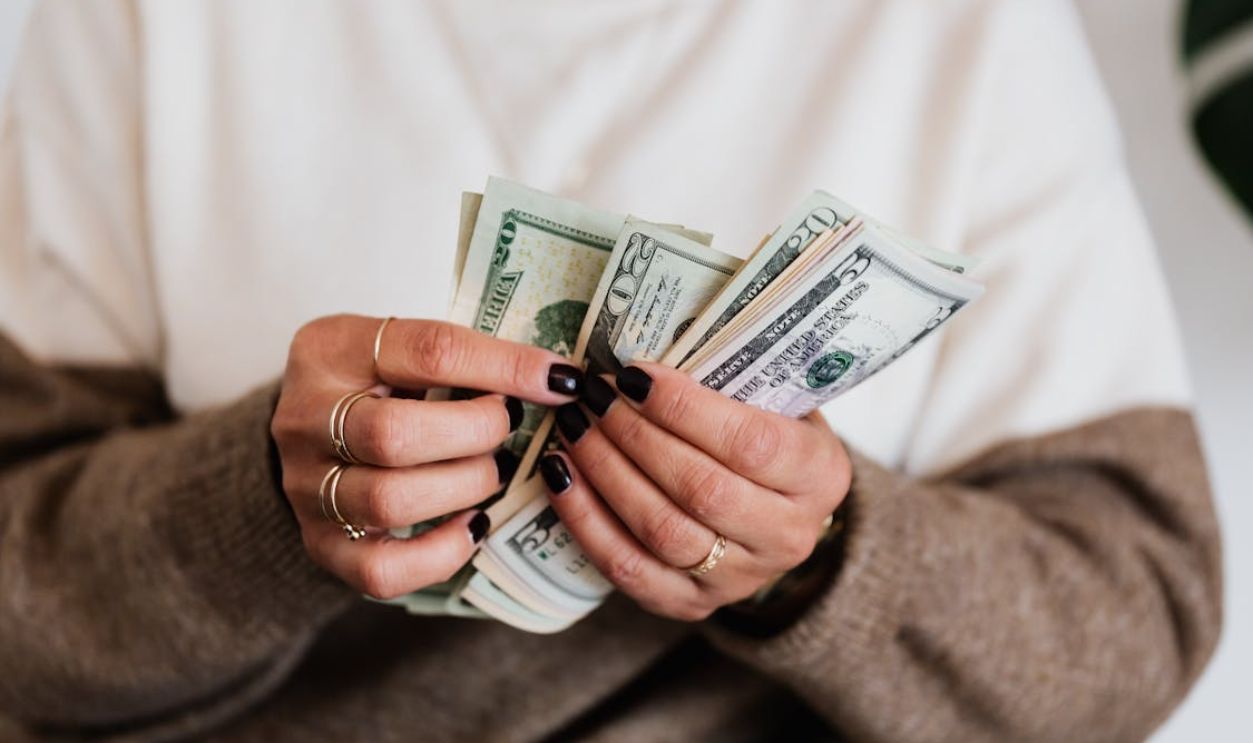 Close-Up Photo of a Person Counting Her Money
