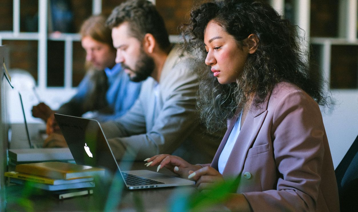 Focused colleagues working on laptops in office