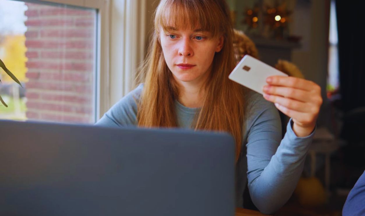 A Woman in Gray Long Sleeve Shirt Looking at the Laptop