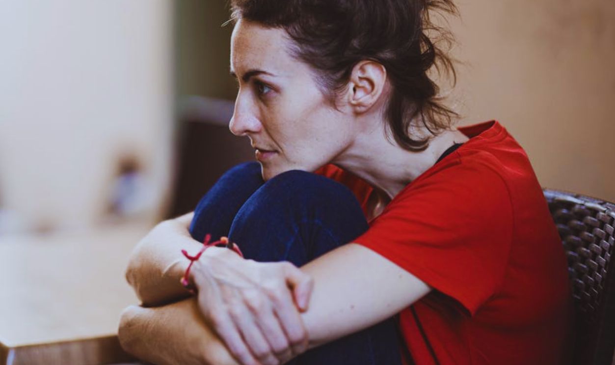 Woman Wearing Red Crew-neck T-shirt Sitting Near the Table