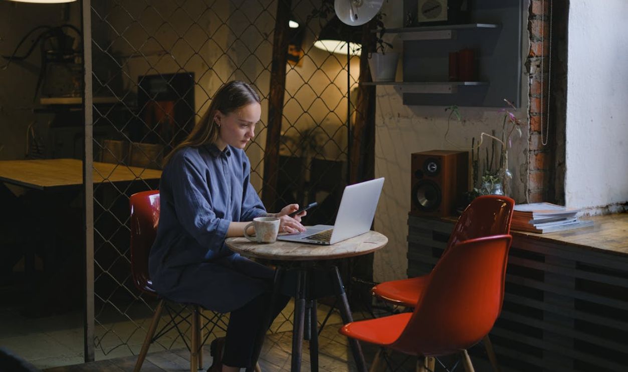 Serious woman browsing laptop in cafe