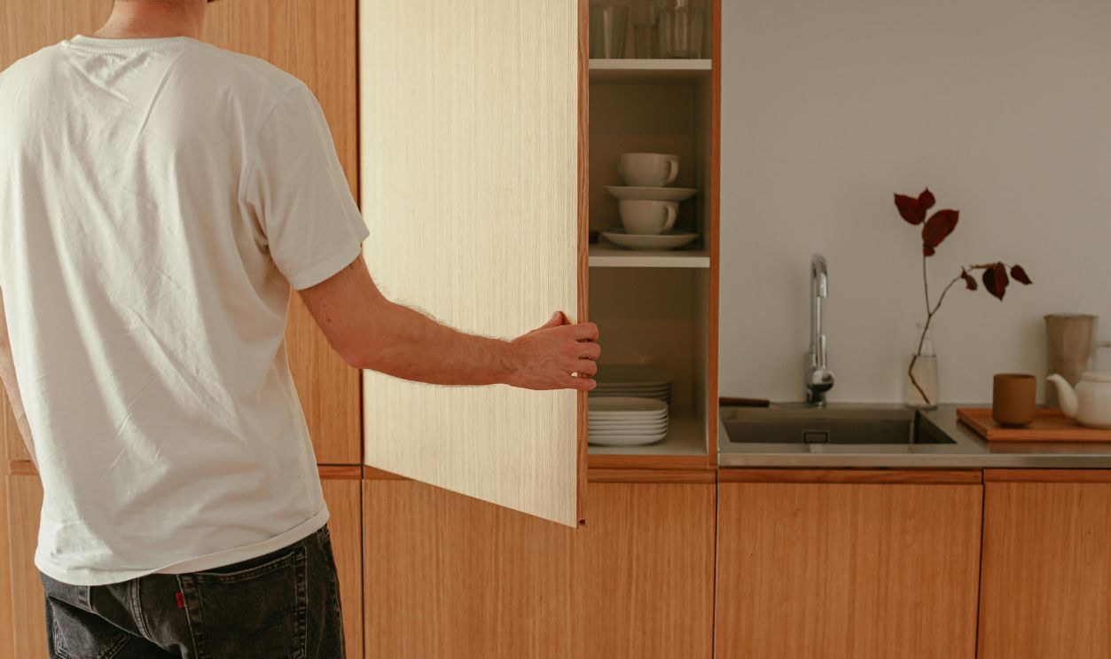 Person Opening a Wooden Cabinet