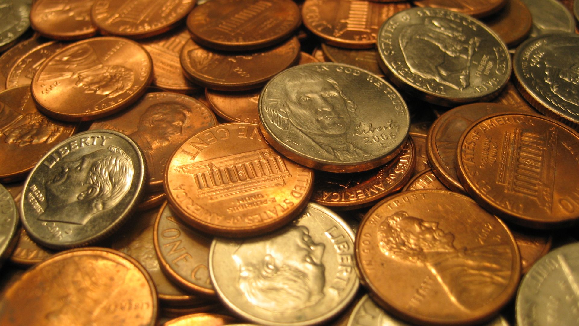 An assortment of United States coins, including quarters, dimes, nickels and pennies.