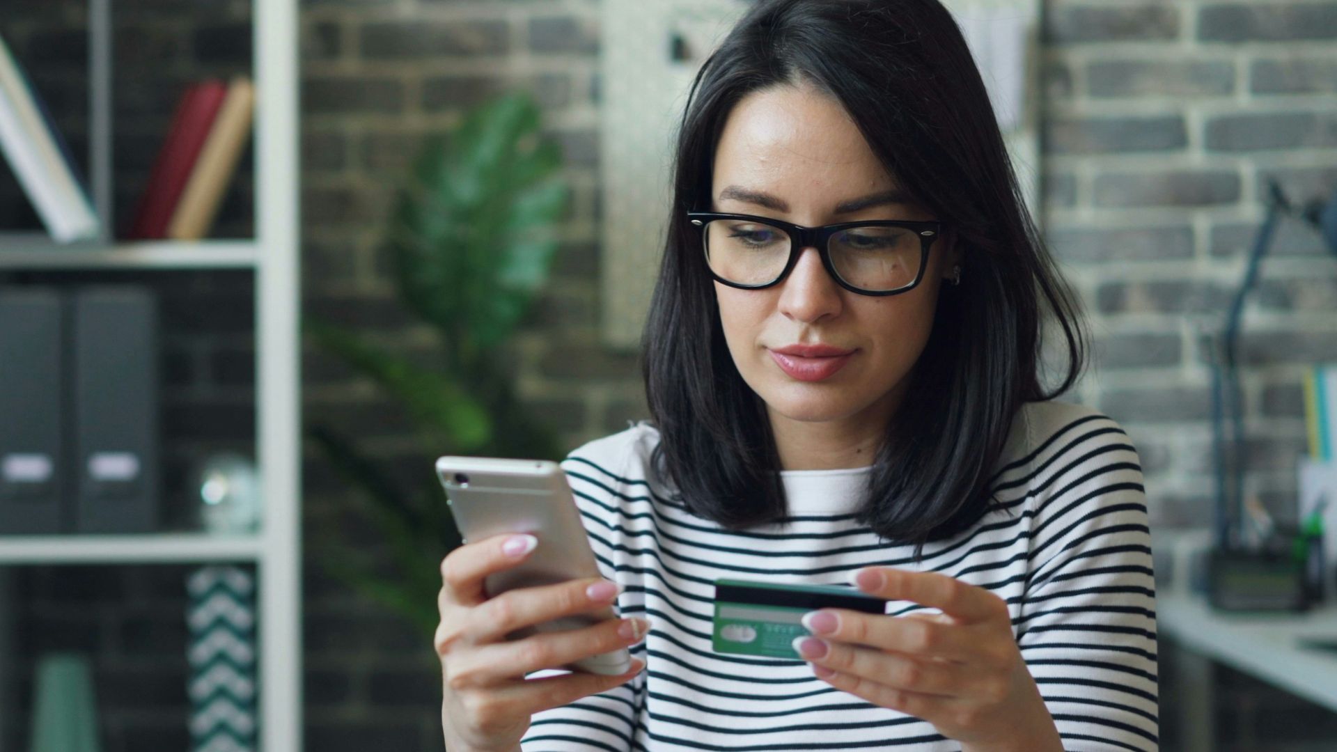 a woman sitting at a table looking at her cell phone