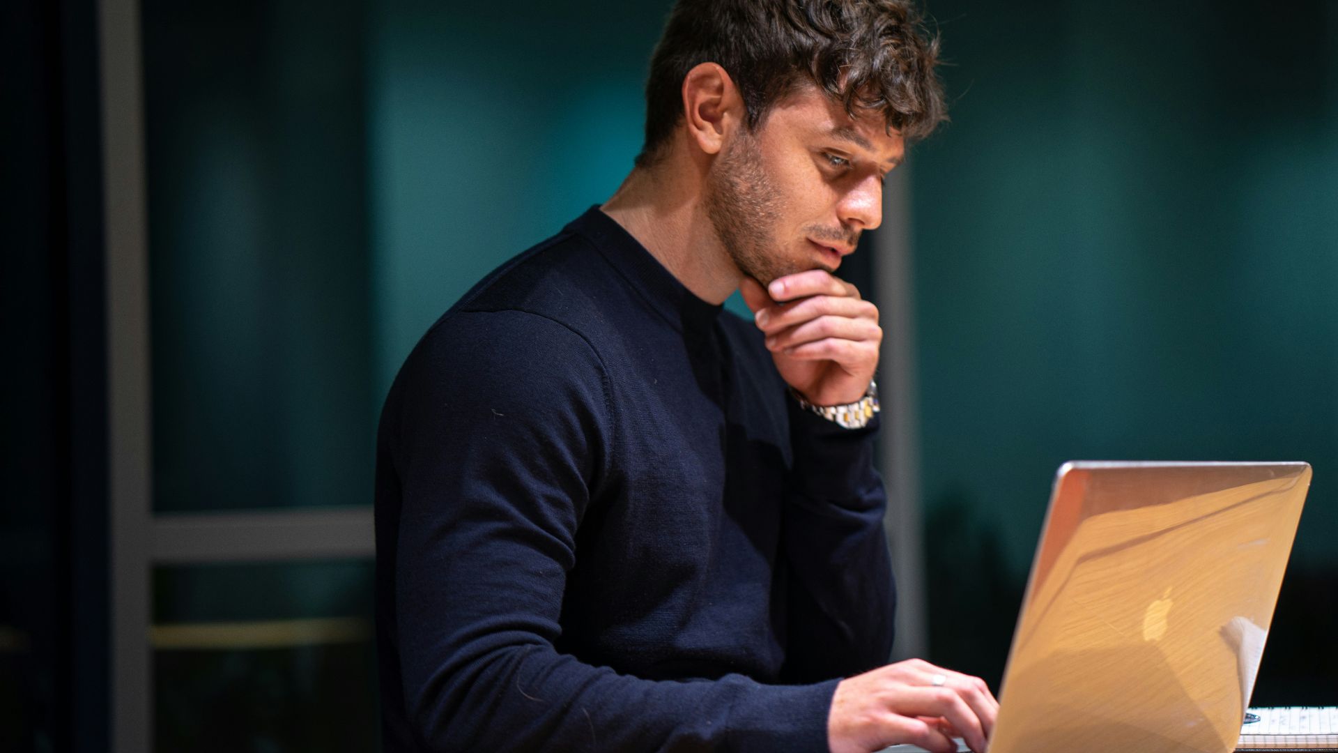 man in black long sleeve shirt sitting in front of macbook