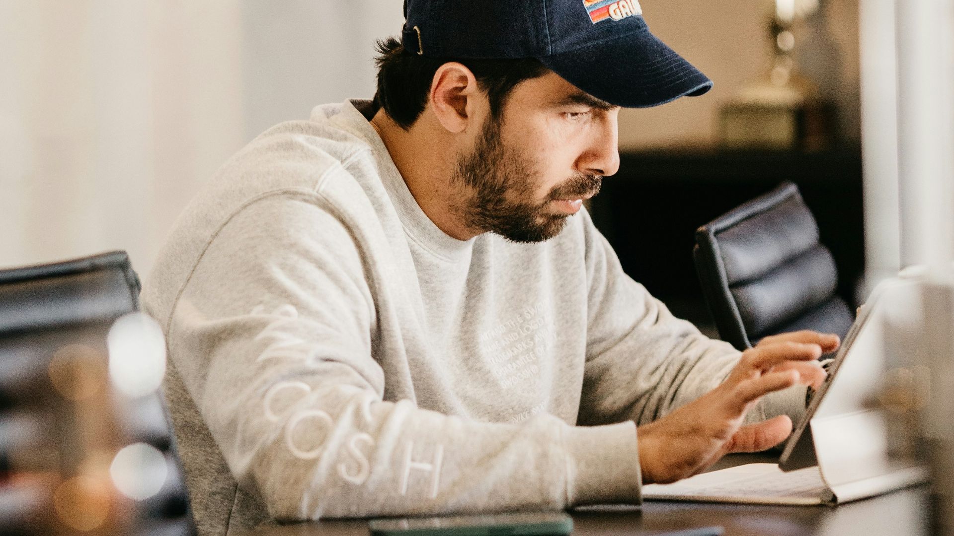 a man in a hat looking at a tablet