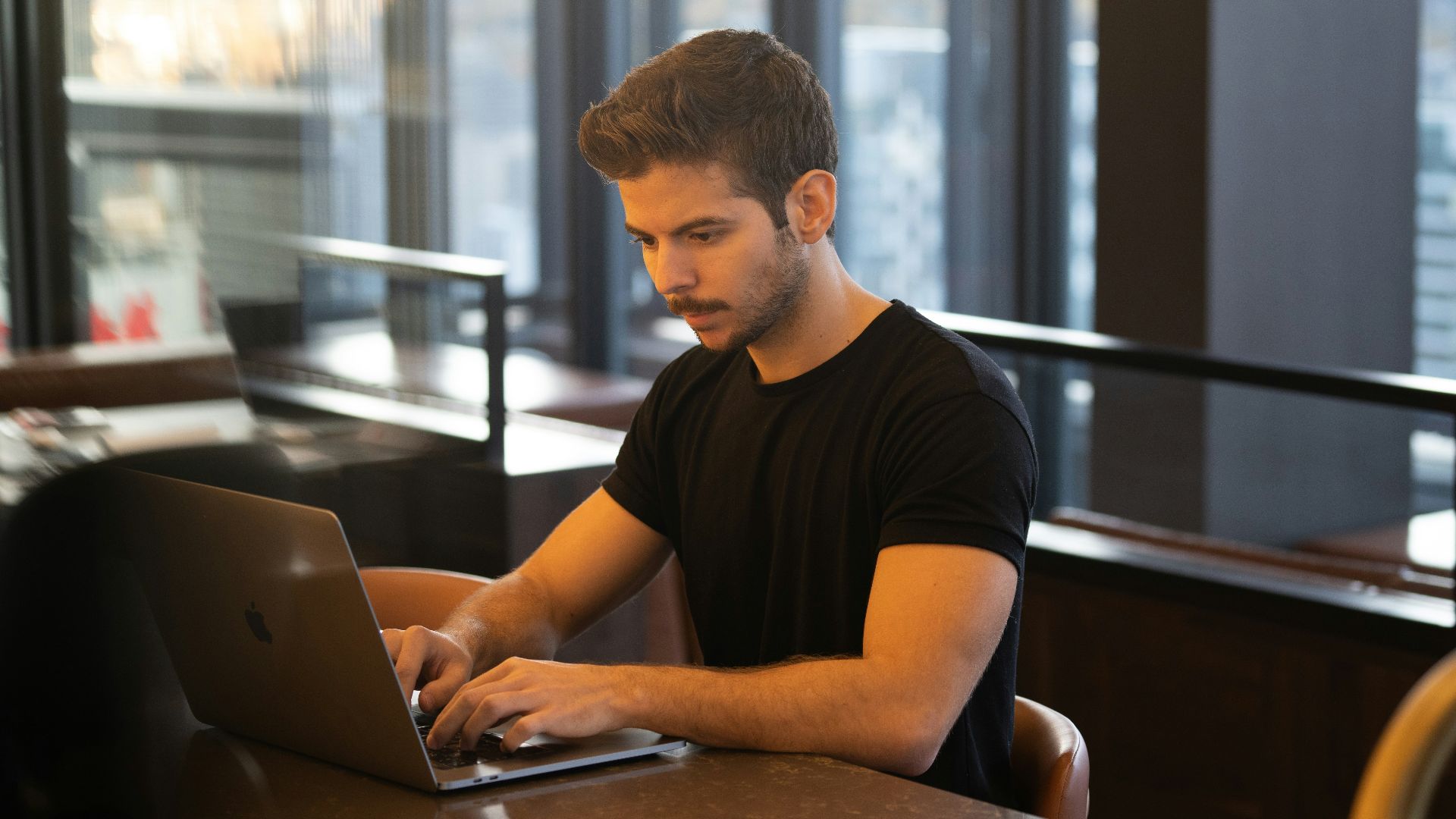 man in black crew neck t-shirt using macbook