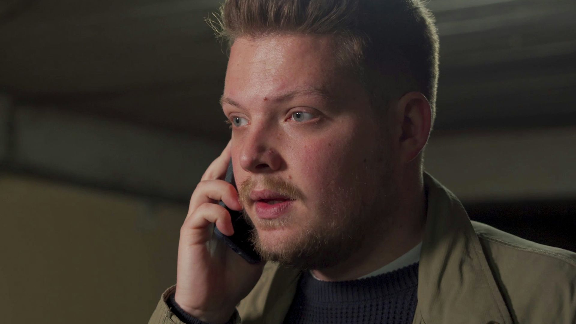 A man talking on a cell phone in a garage
