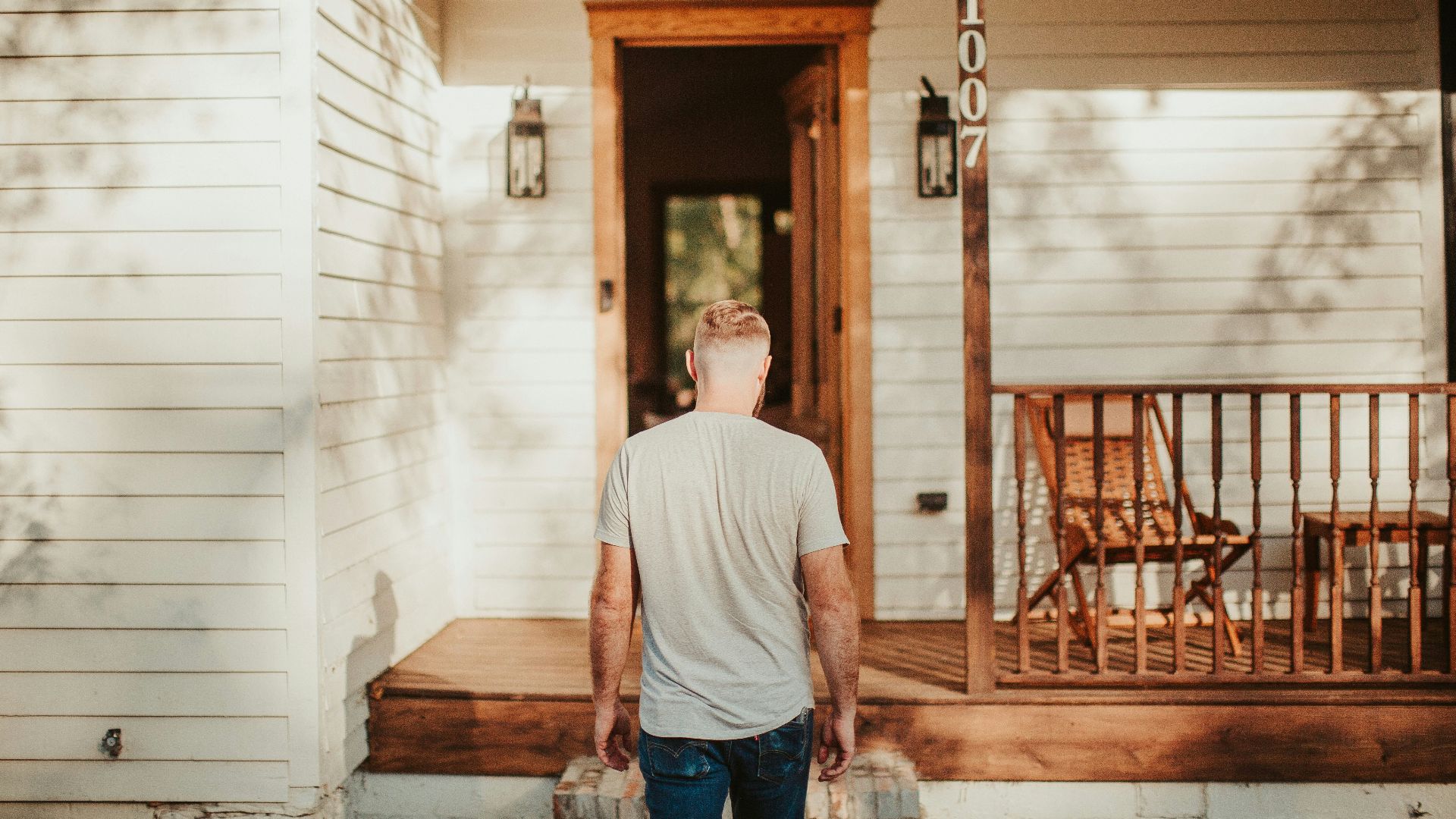 A man is standing outside of a house