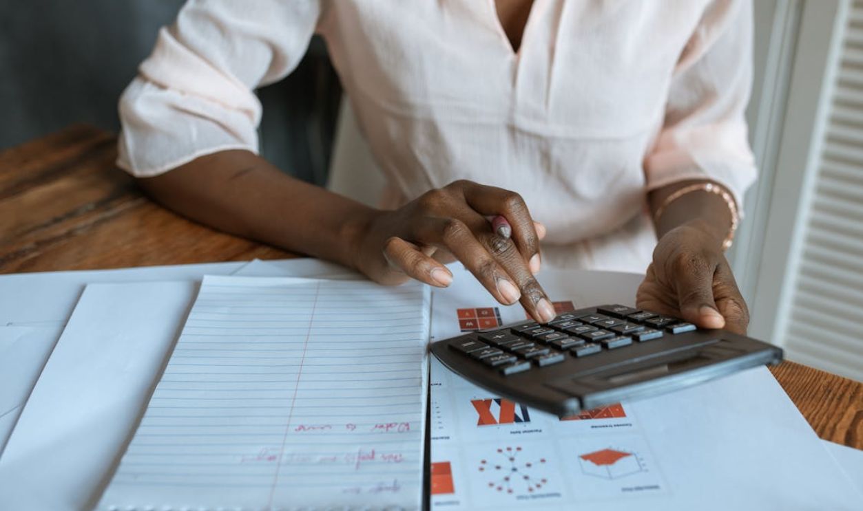Person in White Dress Shirt Using A Calculator