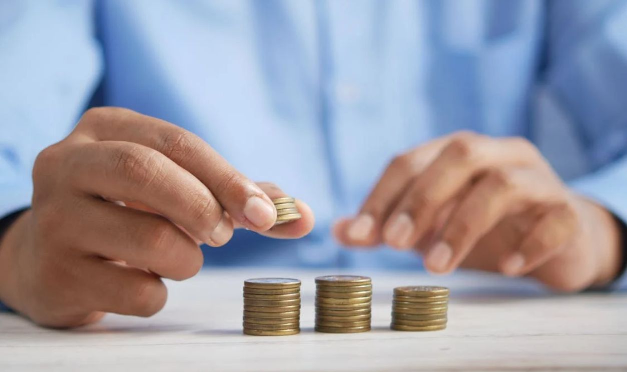 A Close-Up Shot of a Person Stacking Coins
