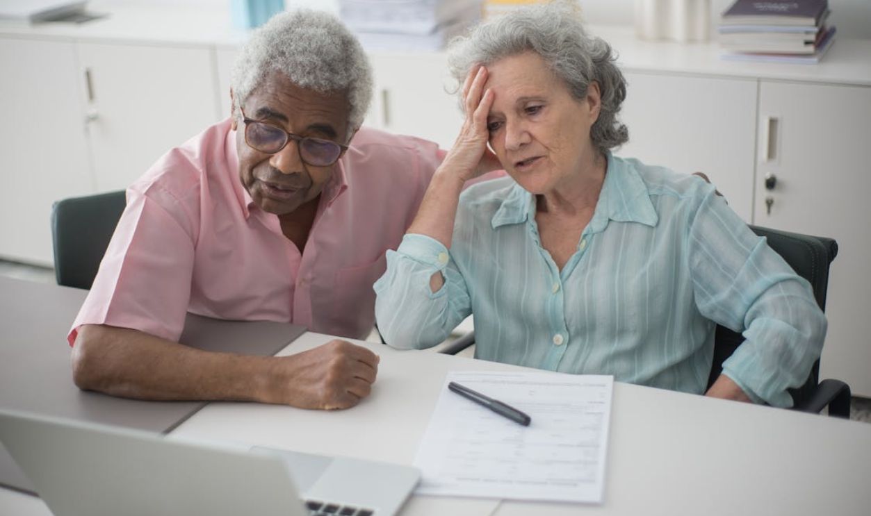 A Man Sitting Beside a Woman with hand on her Head