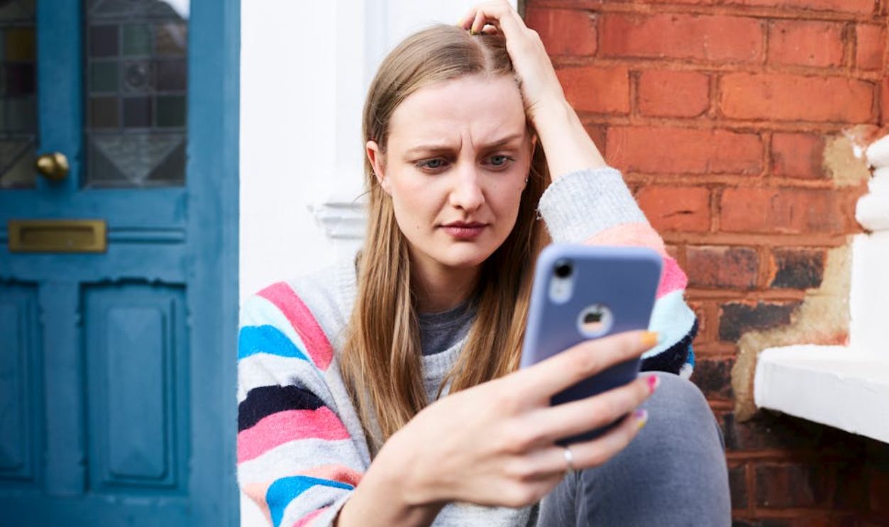 Woman Sitting on Stairs Using Phone