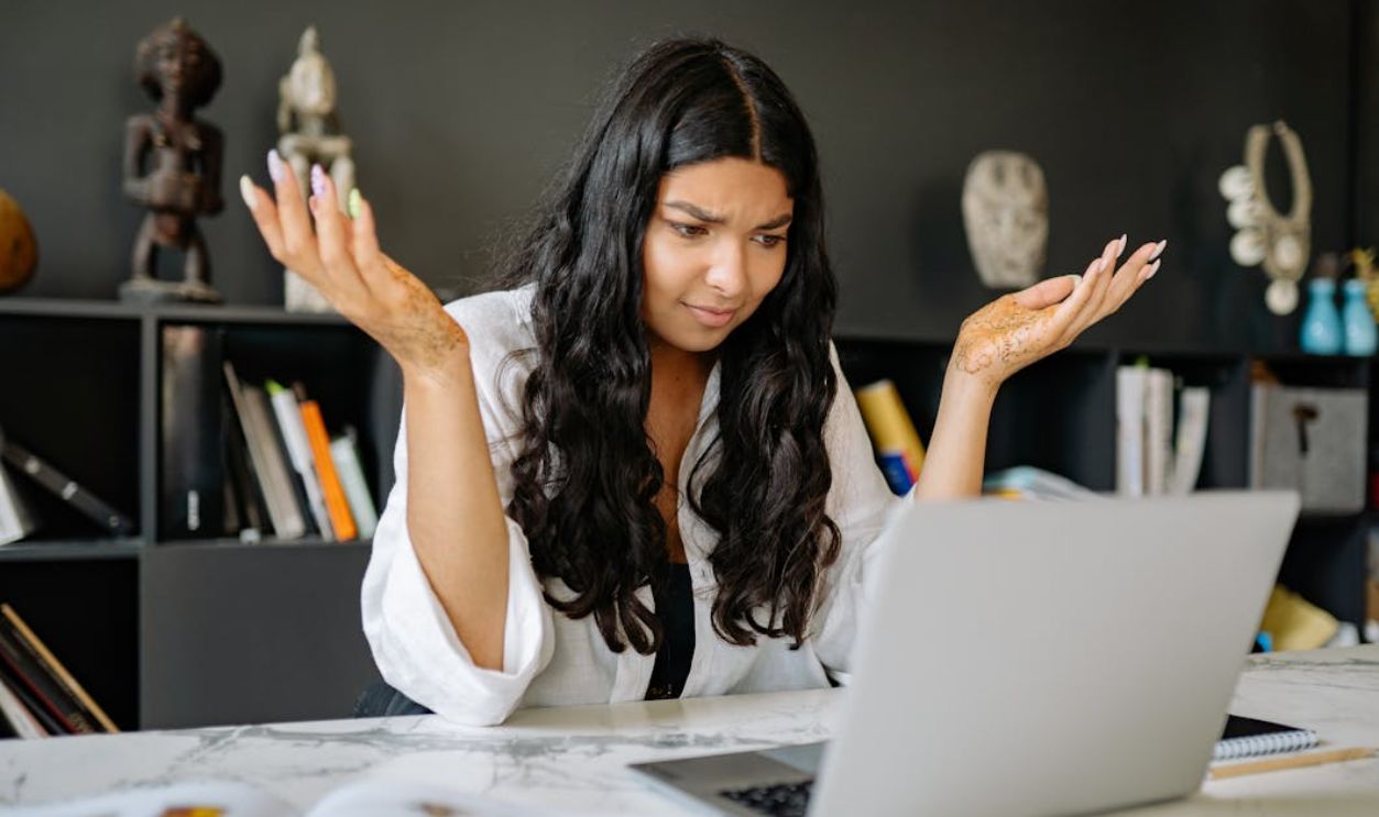 A Woman in White Long Sleeves Using a Laptop