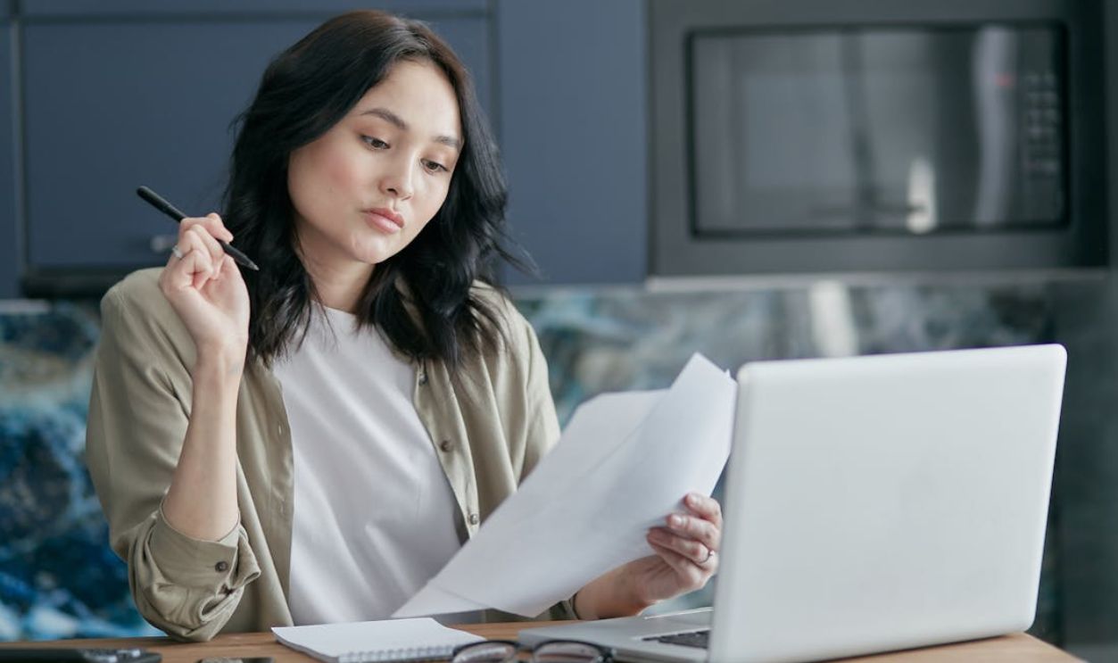 A Woman Looking at White Papers