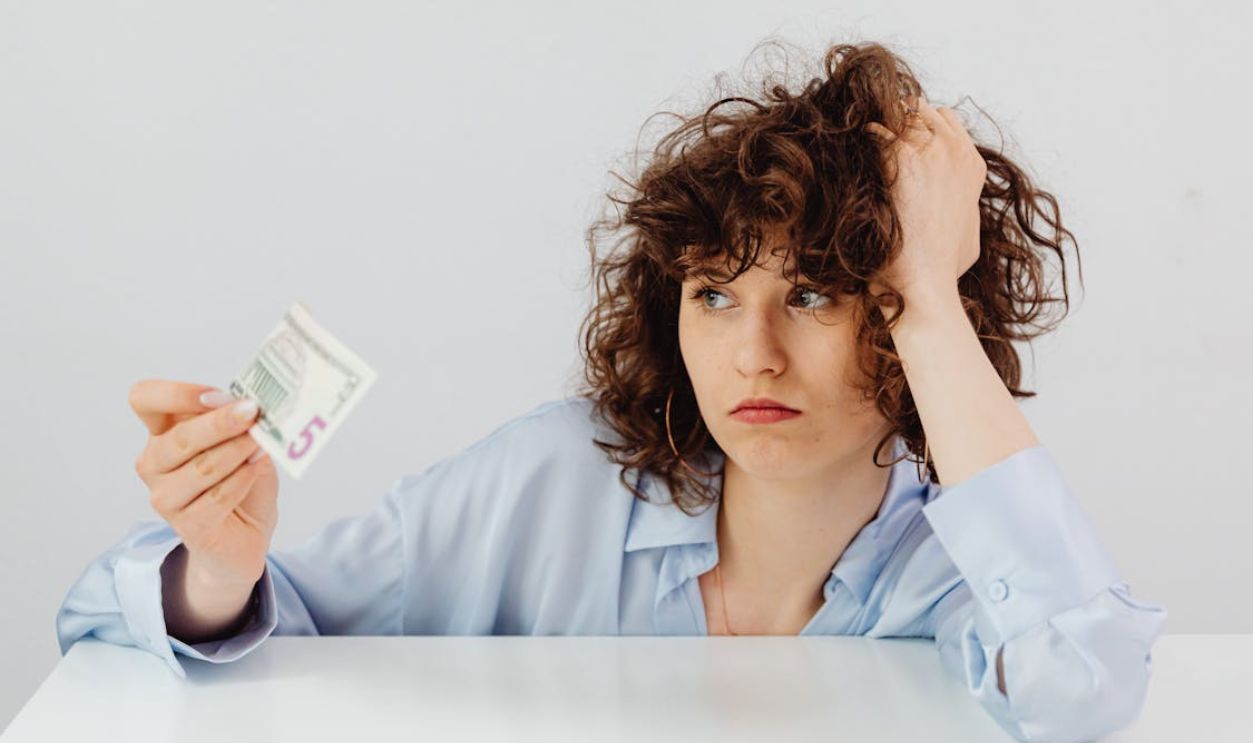 Curly-Haired Woman Holding a Paper Money