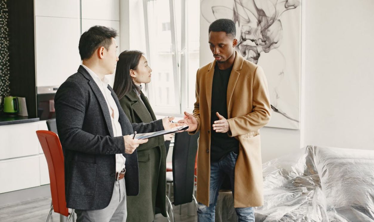 A Man in Brown Coat Explaining Something while Showing His Hands