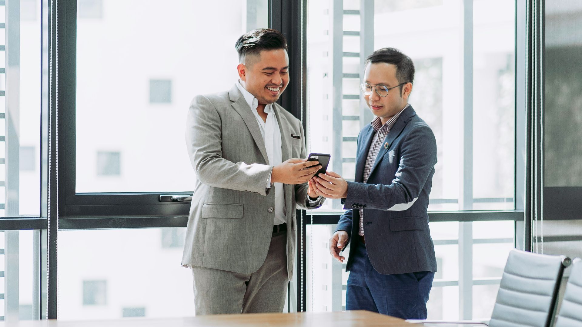 two men shaking hands in a conference room