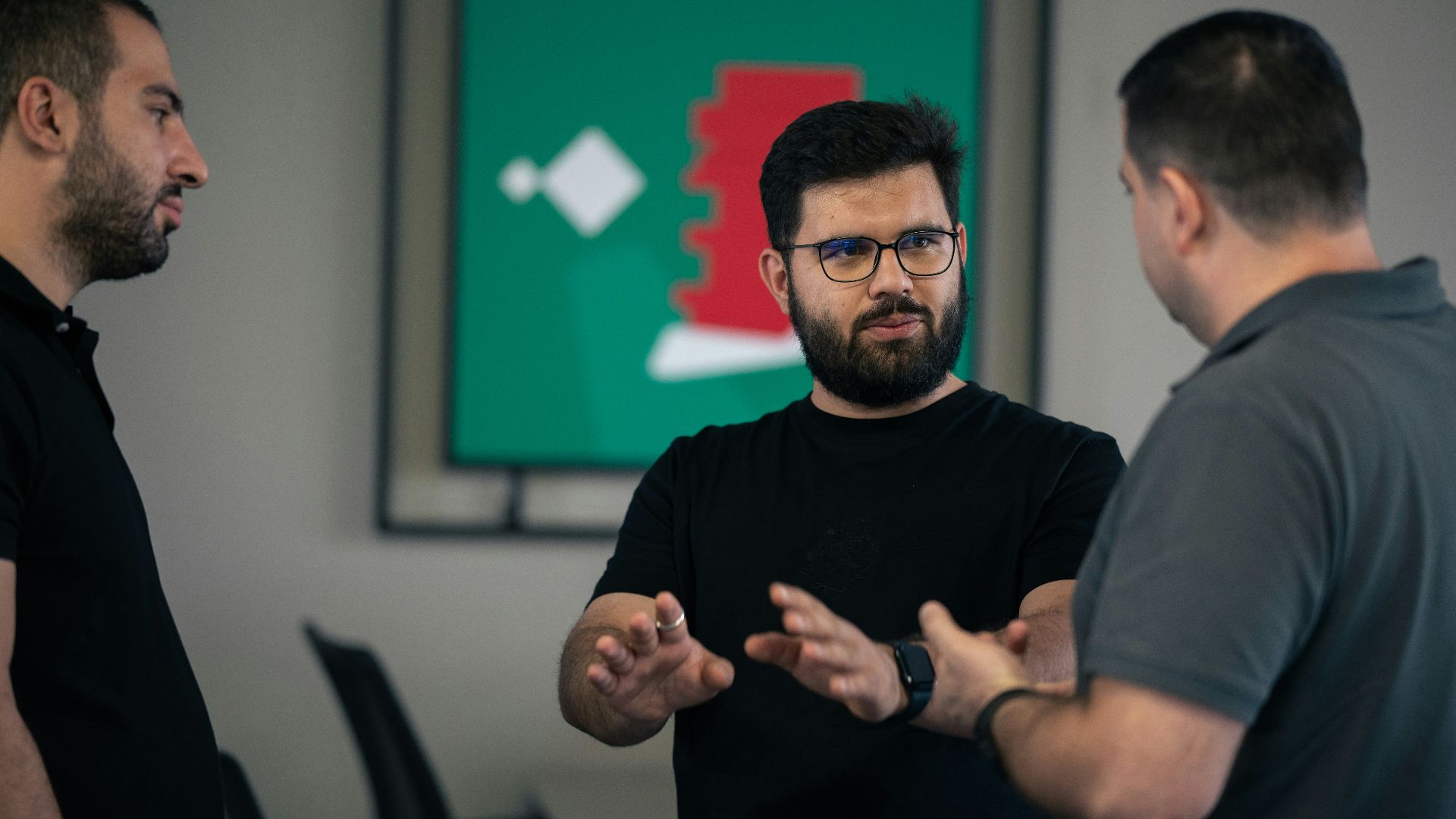 A group of men standing around each other in a room