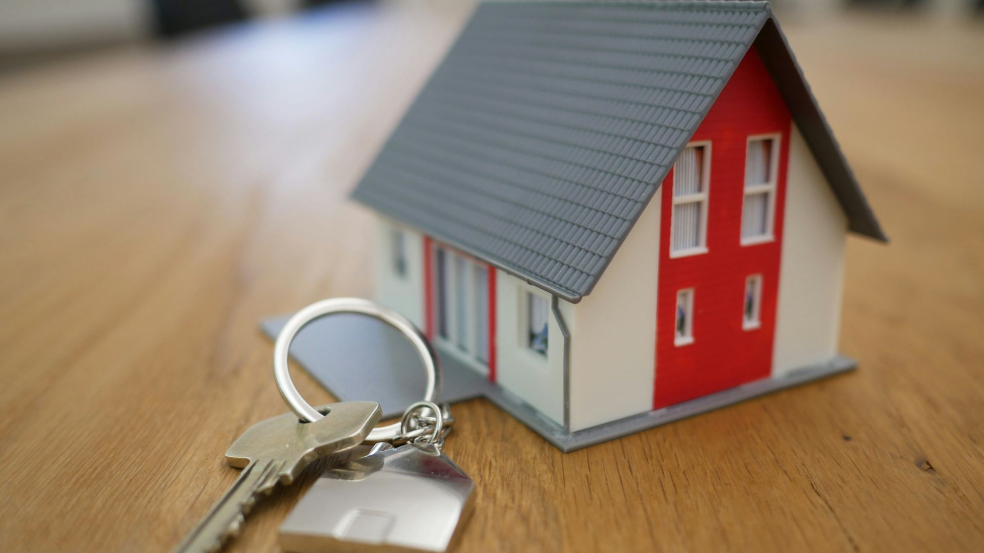 white and red wooden house miniature on brown table